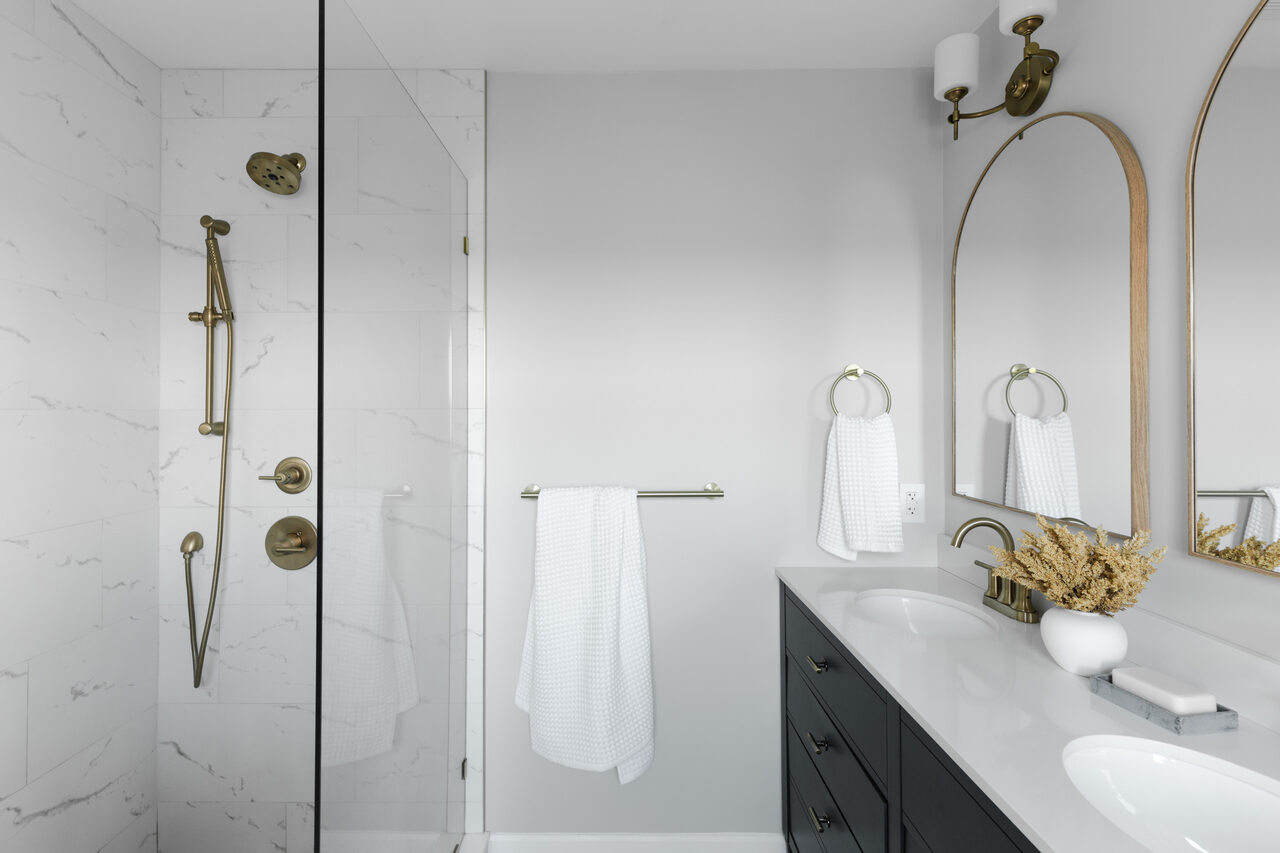 Walk-in shower and double vanity with gold fixtures